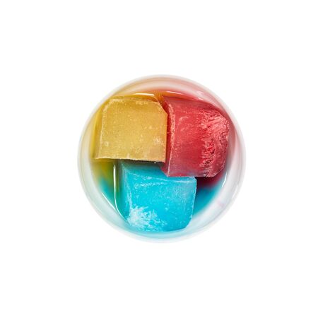Top view of bowl with colorful ice melting on whiteの写真素材