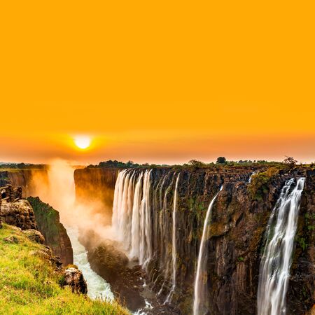 Sunset over Victoria Falls with orange skyの写真素材