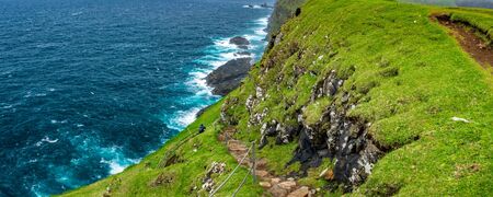 Steep track through the cliffs with touristの写真素材