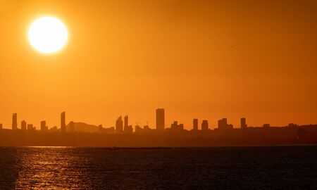 Huge sun and sunset over Benidorm city skyline and seaの写真素材