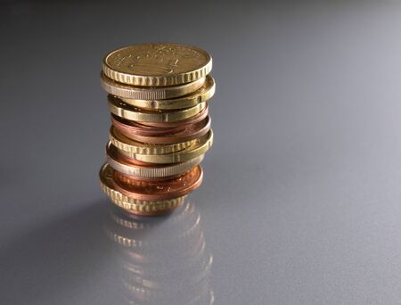 Stacked euro coins with different sizes in a dangerous way, risky business