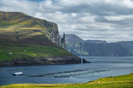 Fish farms in Sandavagur with Witch Finger in the background, faroe islandsの写真素材