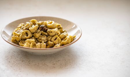Tortellini al pesto over dotted plate closeupの写真素材