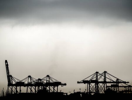 Port cranes silhouette under the stormの写真素材