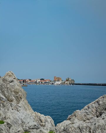 Castro Urdiales marina and cathedral under clear blue sky with text spaceの写真素材