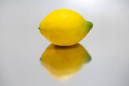 Whole bright yellow lemon isolated and reflectedの写真素材