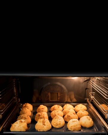 Preparing many cheese breads in home oven with text spaceの写真素材
