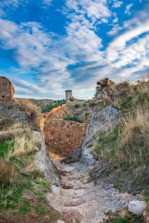 Antique rebuilt tower with ruined walls aroundの写真素材