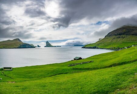 Amazing panorama of Drangarnir gate, Tindholmur and typical housesの写真素材