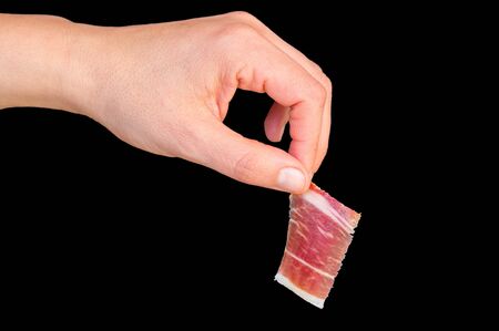 Picking serrano ham on blackの写真素材