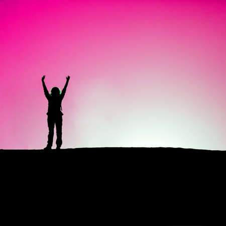 hands up against pink skyの写真素材
