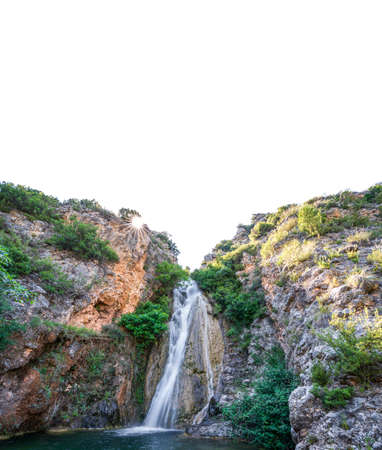 Waterfall with sunstar and clear white skyの写真素材