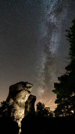 High boulder illuminated under the milky wayの写真素材
