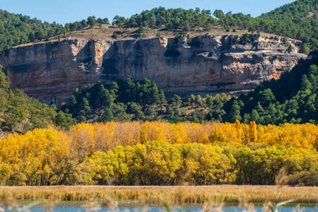 Autumn colors and huge cliffs over the lakeの写真素材