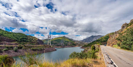 Road, dam and cable suspension bridge over reservoirの写真素材