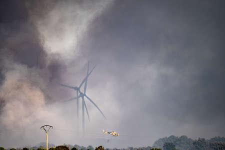 Smoke, windmills and helicopter flying with bambi-bucketの写真素材