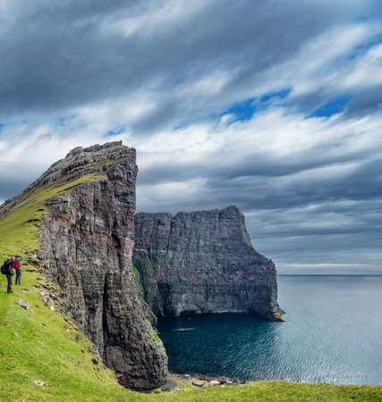 Tourists taking photos of high cliffs in Faroe Islandsの写真素材