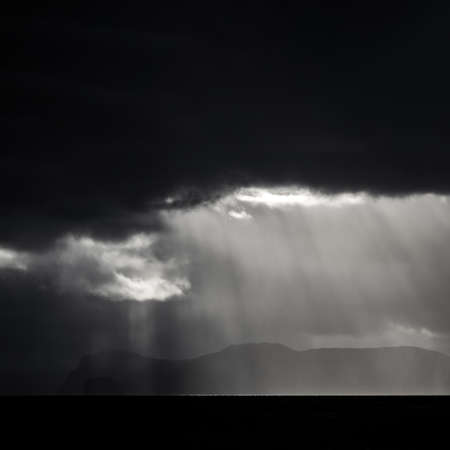 Dark clouds over the island and ocean with ray lightsの写真素材