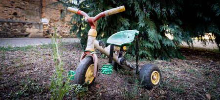 Old abandoned and rusty tricycle closeup viewの写真素材
