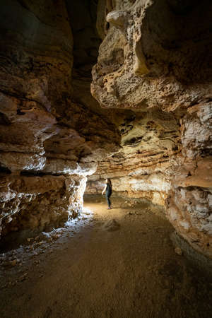 Unrecognizable person entering the cave with lightの写真素材