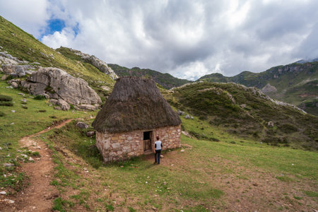 Unrecognizable tourist arrives to mountain hut under the cloudsの写真素材