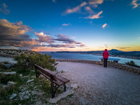 Empty wooden bench and tourist over the bayの写真素材