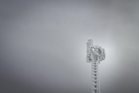 Spectacular communication tower frozen under white skyの写真素材