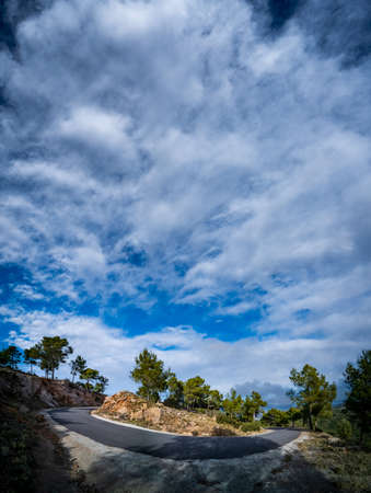 Sharp bend under cloudy sky for text spaceの写真素材
