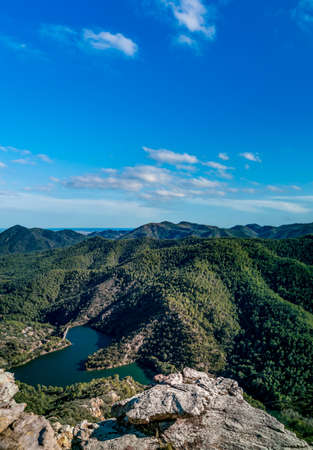 Rocks viewpoint over mountain range and damの写真素材