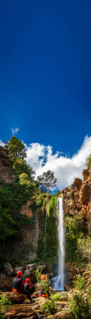 Unrecognizable people enjoy waterfall descent with text spaceの写真素材