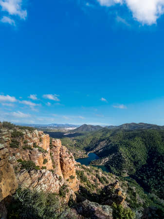 Rocks with layers, mountain range and damの写真素材