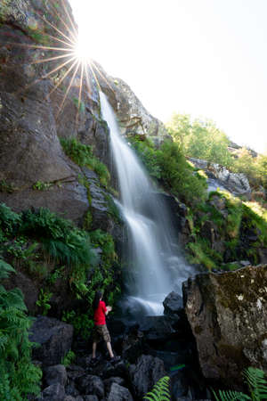 Unrecognizable person under the waterfall, long exposureの写真素材