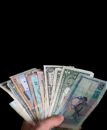 Hand holding different kind of bills over blackの写真素材