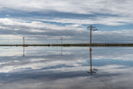Flooded fields with electric towers after the stormの写真素材