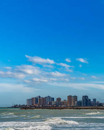 Plain coastline with high buildings and blue skyの写真素材