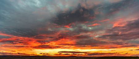 Deep red cloudy sunset with mountain rangeの写真素材