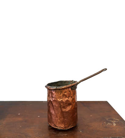 Antique copper saucepan over the table and white backgroundの写真素材