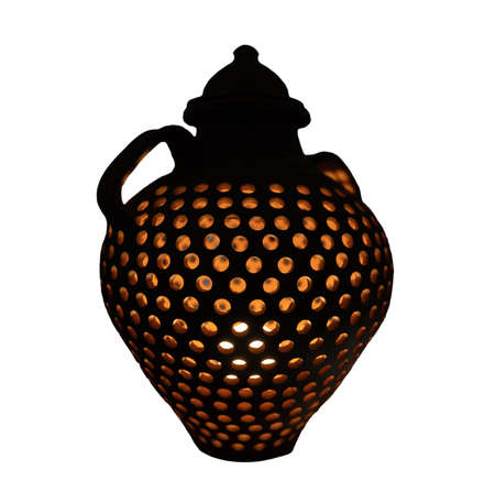 Pot with light inside it and holes over whiteの写真素材