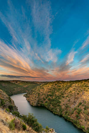 River and canyon at sunset with pink clouds, vertical compositionの写真素材
