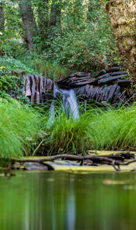Waterfall long exposure, slate dam and stream, vertical compositionの写真素材