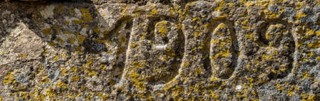 Vintage 1909 number text carved over the rockの写真素材