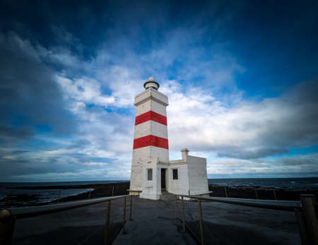 Isolated lighthouse under the cloudy sky in Icelandの写真素材