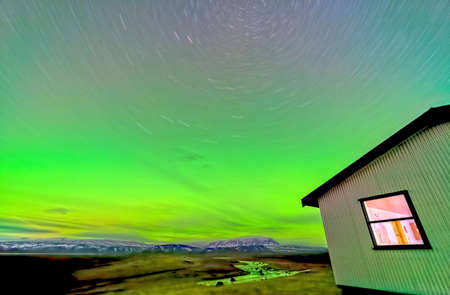 Aurora borealis lights, river and house long exposureの写真素材