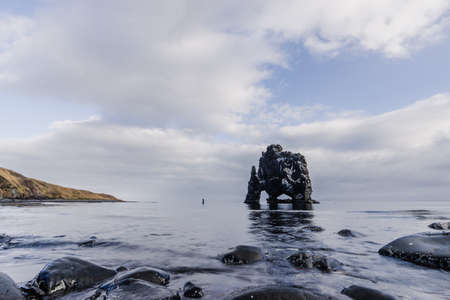 Hvitserkur boulder and tourist in the middle of the routeの写真素材
