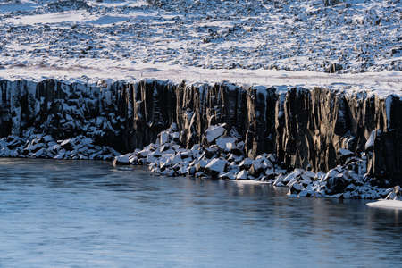 Boulder cubes under the cliffs with snowの写真素材