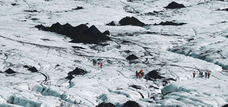 Many groups of hikers hiking over the massive glacierの写真素材