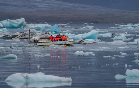 Icebergs in Jokulsarlon and rear view of tourist boatの写真素材