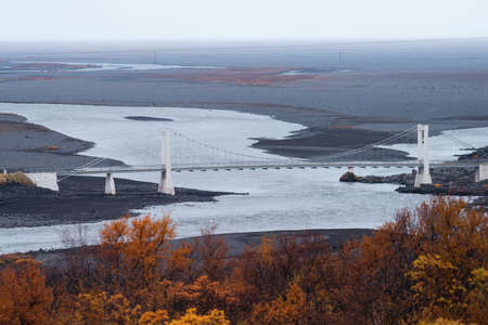 River and suspension bridge in Iceland on autumnの写真素材