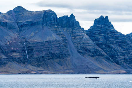 Fjord, road and huge colorful mountains, long shotの写真素材