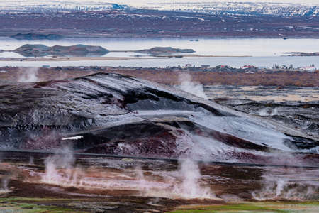 Myvatn lake with many fumaroles and residential housesの写真素材